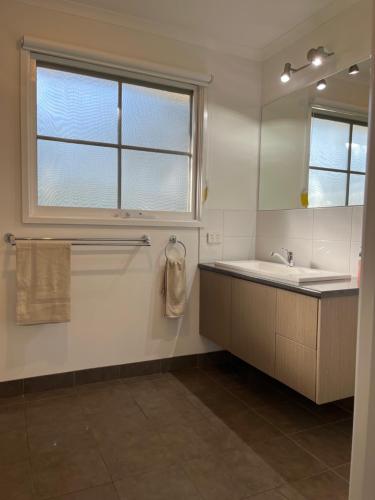 un bagno bianco con un lavandino e una finestra di River Frontage Unit Moama a Moama