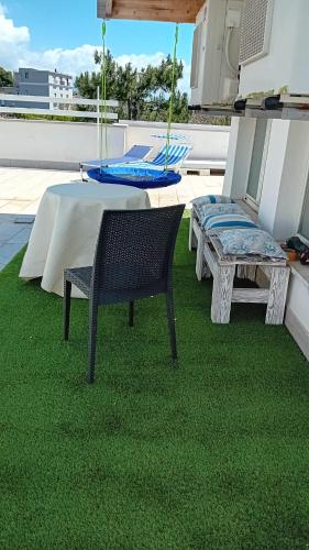 a patio with a table and a bench on the grass at Casa di Nonna Margherita in Trecase