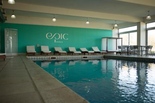 a swimming pool with chairs and tables in a building at Epic Hotel San Luis in La Punta