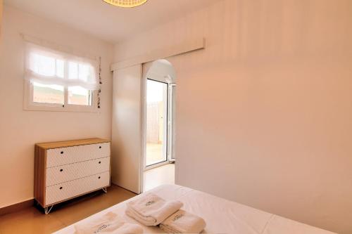 a bedroom with a bed and a window and a dresser at Atic Els Pins in L'Estartit