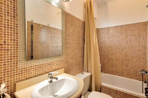 a bathroom with a sink and a toilet and a mirror at Atic Els Pins in L'Estartit