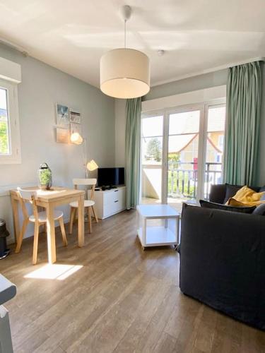 a living room with a table and a dining room at Port-Guillaume, résidence de vacances avec mer & piscine in Dives-sur-Mer