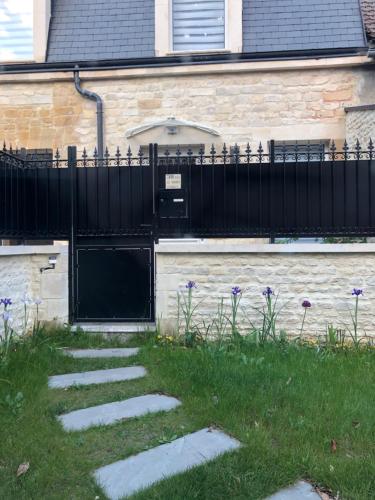 a house with a black gate and a walkway at Ogma, Studio coquet au calme in Caen