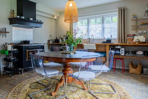 a kitchen with a table and chairs and a kitchen with a sink at Landgoed Olterterp Lodges, kies een comfortabel huisje of appartement op de allermooiste locatie in Olterterp