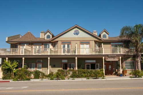 a large house with a balcony on a street at Cayucos Sunset Inn in Cayucos