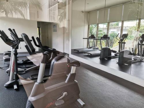 a gym with several treadmills and elliptical machines at By The Sea Beach Front and Seaview Apartment 2 in Batu Ferringhi