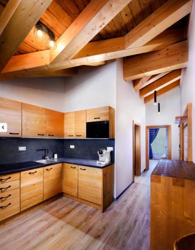a kitchen with wooden cabinets and wooden ceilings at CHALET MOUNTAIN in Demanovska Dolina