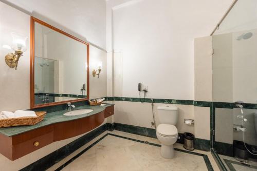 a bathroom with a toilet and a sink and a mirror at Umed Bhawan Palace, Kotah in Kota