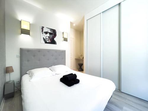 - une chambre dotée d'un lit blanc avec un sac noir dans l'établissement Moderne, calme et bien équipé, à 200m de la plage, à Cannes
