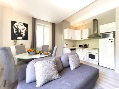 un salon avec un canapé et une table dans une cuisine dans l'établissement Moderne, calme et bien équipé, à 200m de la plage, à Cannes