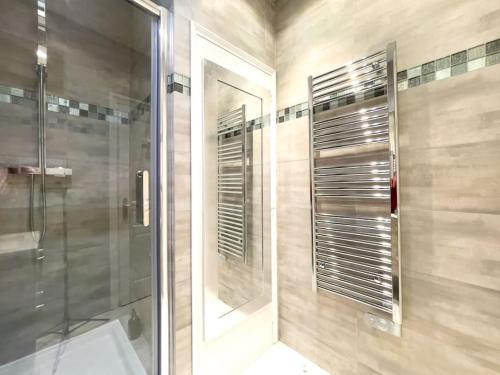 La salle de bains est pourvue d'une douche et d'une cabine de douche en verre. dans l'établissement Moderne, calme et bien équipé, à 200m de la plage, à Cannes