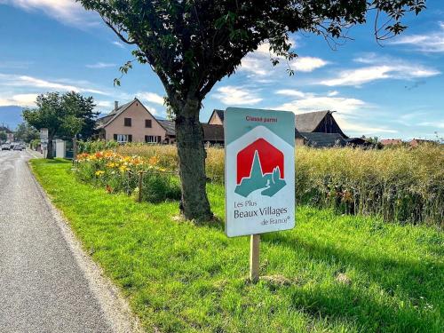 a sign on the side of a road next to a tree at Charmant studio avec parking in Eguisheim