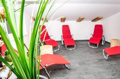 a waiting room with red chairs and a plant at Haus Schnöll Top 7 in Mittersill