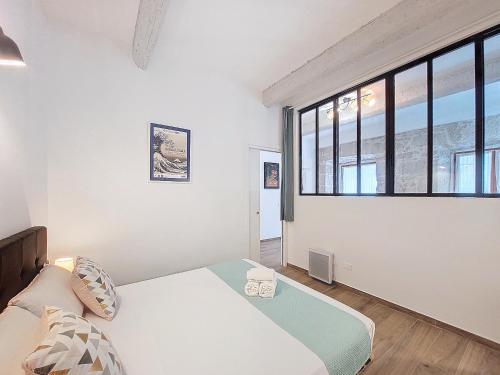 une chambre avec un lit et une grande fenêtre dans l'établissement Nestor&Jeeves - VILLA FAY - Near Beach - Promenade, à Nice