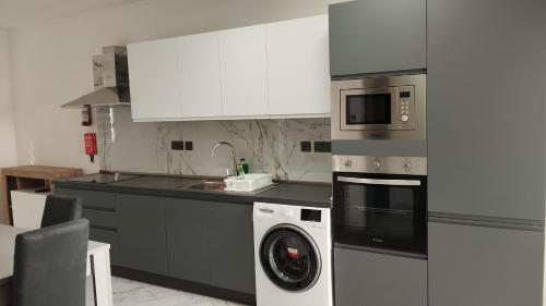 a kitchen with a washing machine and a microwave at NR89 Apartments, by ferry to Valletta in 10 minutes in Il-Gżira