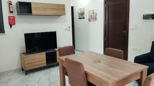 a living room with a wooden table and a television at NR89 Apartments, by ferry to Valletta in 10 minutes in Il-Gżira