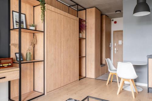 a room with wooden dividers and a table and chairs at RentPlanet - Apartamenty Zarembowicza in Wrocław