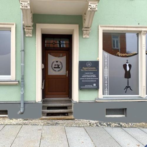 a building with a door and a mannequin in a window at Zur Alten Schneiderei Kamenz in Kamenz
