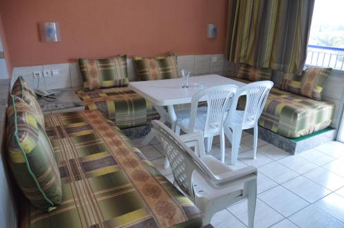 a living room with a table and chairs and a couch at Residence Yasmina Agadir in Agadir
