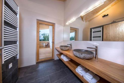 a bathroom with two sinks and a large mirror at Chalet Zillertal Arena 1 in Kirchdorf