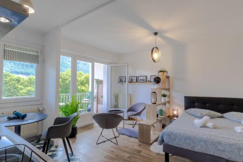 une chambre avec un lit, une table et des chaises dans l'établissement Mont-Lac - Free parking - By a park - Mountain view - near lake, à Annecy