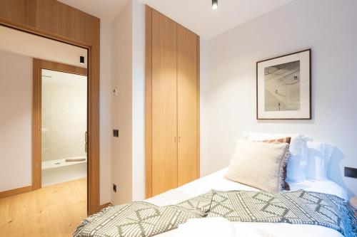 a bedroom with a bed and a wooden closet at Isard Homes by Select Rentals in El Tarter