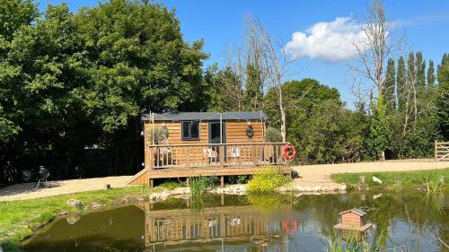 谢菲尔德Rusty Duck Retreat Shepherds Hut的池塘中的小木屋