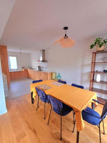 une salle à manger avec une table et des chaises bleues dans l'établissement Lomener-Maison plage à pied-Surfs et Paddles, à Ploemeur