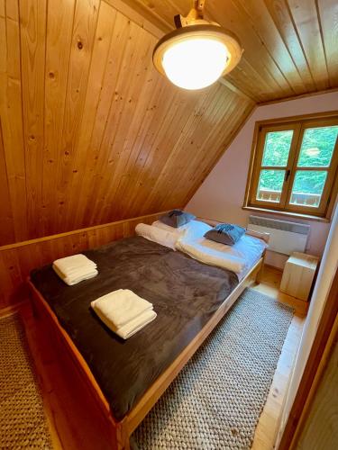 a bedroom with a bed in a wooden cabin at Baranówka in Kamesznica