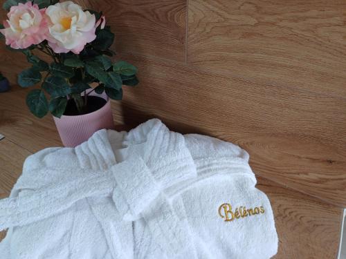 a white sweater next to a vase with flowers at Bélénos - Suites & Spa in Bligny-sur-Ouche