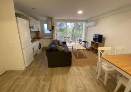 eine Küche und ein Wohnzimmer mit einer Couch und einem Tisch in der Unterkunft Apartment at the foot of Pantano San Juan - 12 in Madrid