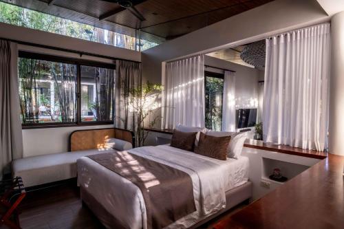 a bedroom with a bed and a large window at Vijaya Cabin - Ezra Viniti Resort in Tagaytay