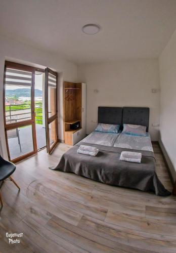 a bedroom with a large bed and a wooden floor at Pokoje Gościnne nad Rożnowskim in Gródek Nad Dunajcem