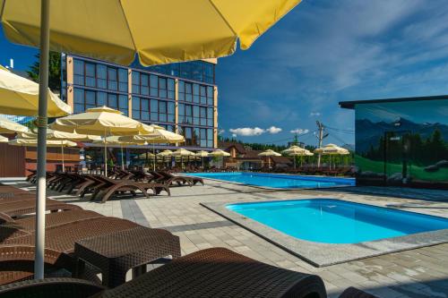 a resort with a pool and chairs and umbrellas at Summit in Yablunytsya