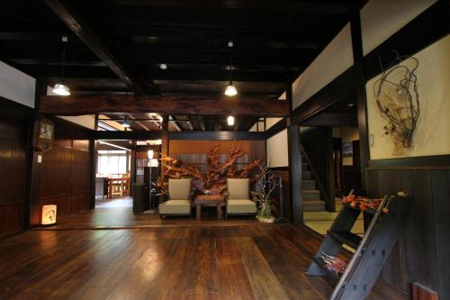 a lobby with a table and chairs and a tree at Minshuku Takizawa in Takayama