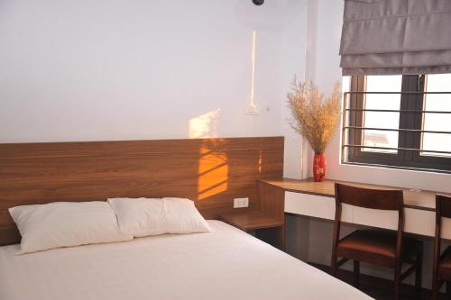 a bedroom with a bed and a desk and a window at Hoa Hồng 301MD in Hanoi