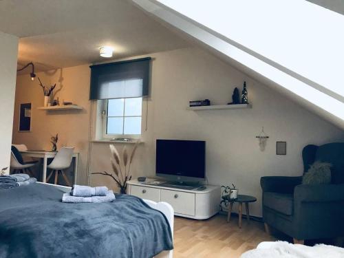 LütowにあるKleine Ferienwohnung mit Hundのベッドとテレビと椅子のある寝室