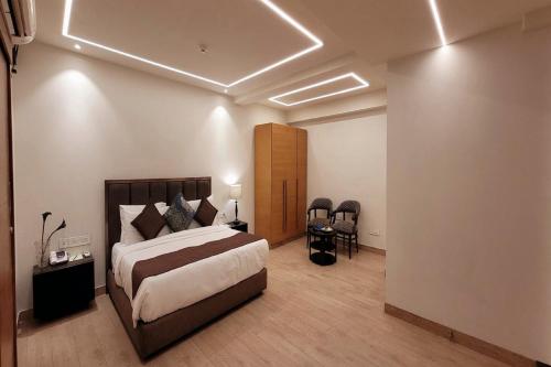 a bedroom with a bed and a table and chairs at Hotel Saket 27 in New Delhi