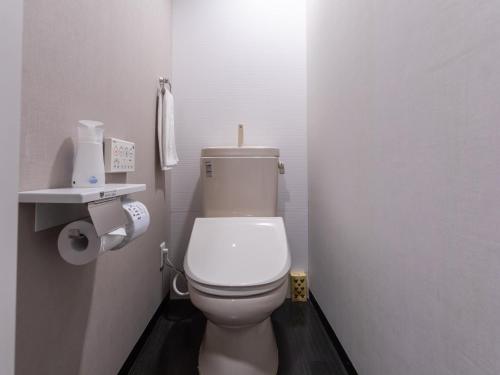 a bathroom with a white toilet in a stall at Tabist Takamatsu Pearl Hotel in Takamatsu