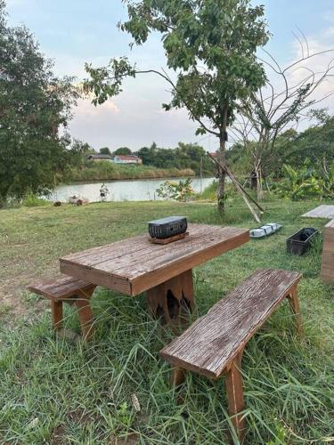 a wooden picnic table with a tire on top of it at Tiny home by the River in Thailand in Phra Nakhon Si Ayutthaya