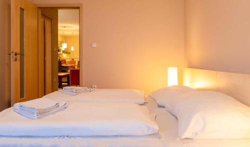 two beds in a hotel room with white pillows at Súkromné apartmány v Crocuse s výhľadom na hory in Štrbské Pleso