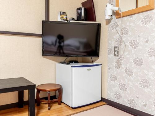 a flat screen tv sitting on top of a refrigerator at Tabist Takamatsu Pearl Hotel in Takamatsu