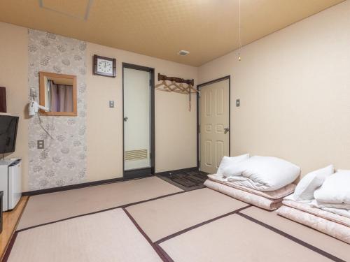 a living room with two chairs and a door at Tabist Takamatsu Pearl Hotel in Takamatsu
