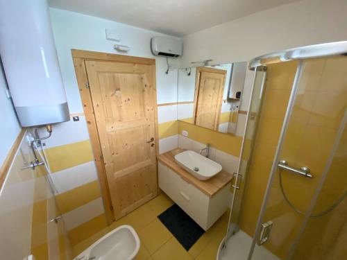 a bathroom with a sink and a toilet and a shower at Casa della marmotta in Marilleva