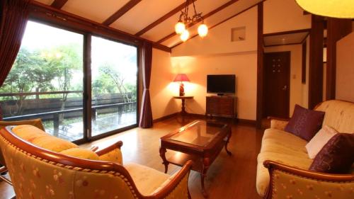 a living room with a couch and a table at Auberge A MA FACON in Kokonoe