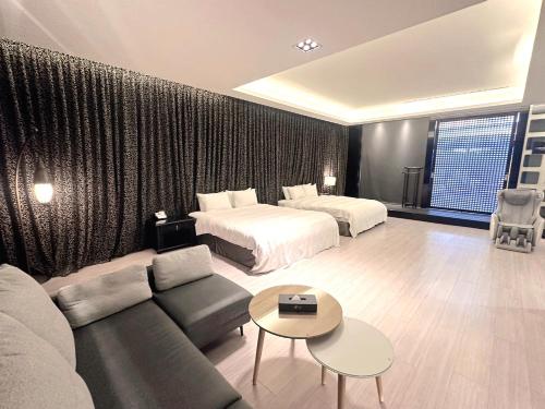 a hotel room with a couch and a bed at Orient Luxury Villa Motel in Huwei