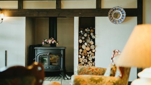 a living room with a fireplace and a fire place at Auberge A MA FACON in Kokonoe