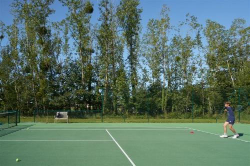 a person playing tennis on a tennis court at Les Sources de Cheverny in Cheverny