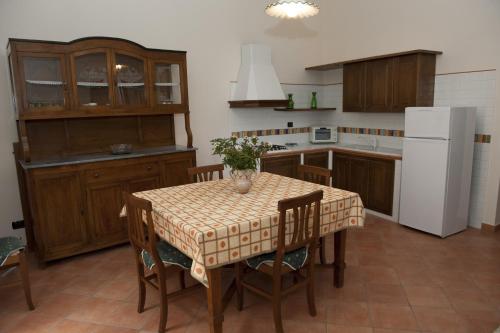 a kitchen with a table with chairs and a white refrigerator at Casa Lippi in Casal Velino