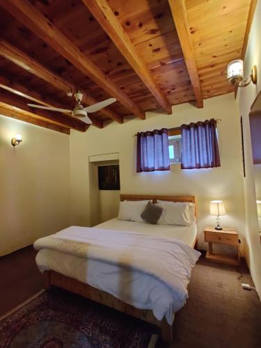a bedroom with a large bed with blue curtains at The vintage guest house Skardu in Skardu